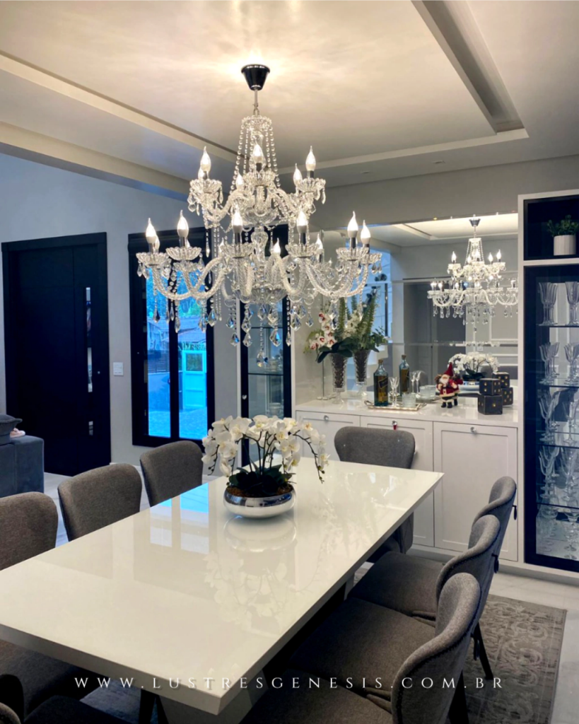 Sala de jantar sofisticada com lustre de candelabro com cristal e decoração elegante.