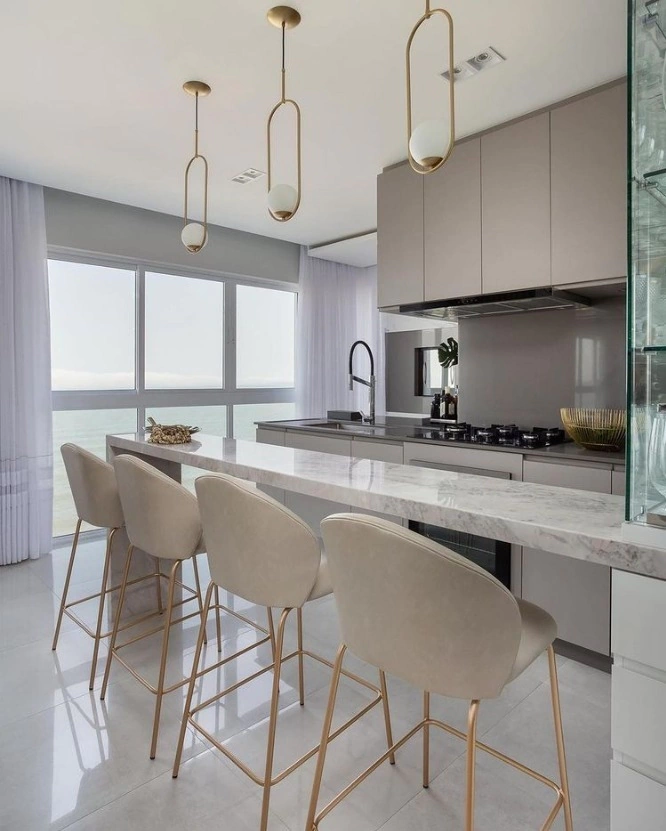 Lustres pendentes modernos em cozinha com vista para o mar.