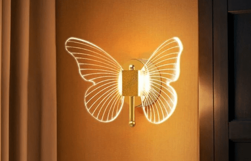 Arandela dourada em formato de borboleta com luzes nas asas