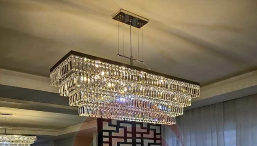 Lustre retangular de cristal com camadas brilhantes e design sofisticado.