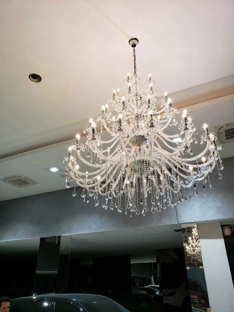 Lustre candelabro cristal luxuoso com várias camadas e acabamento brilhante.