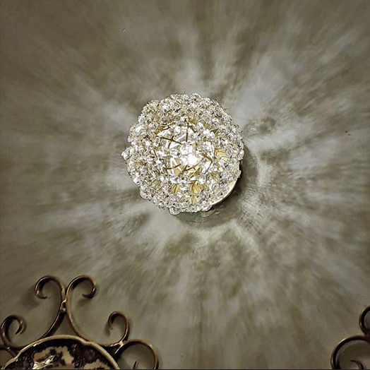 Lustre de cristal emitindo reflexos luxuosos no teto.