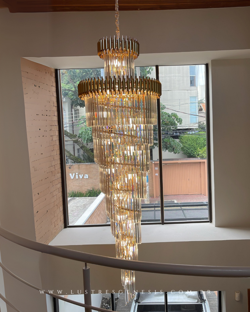 Lustre de cristal imponente em vão de escada com pé-direito duplo foto de cliente do mês da lustres genesis.