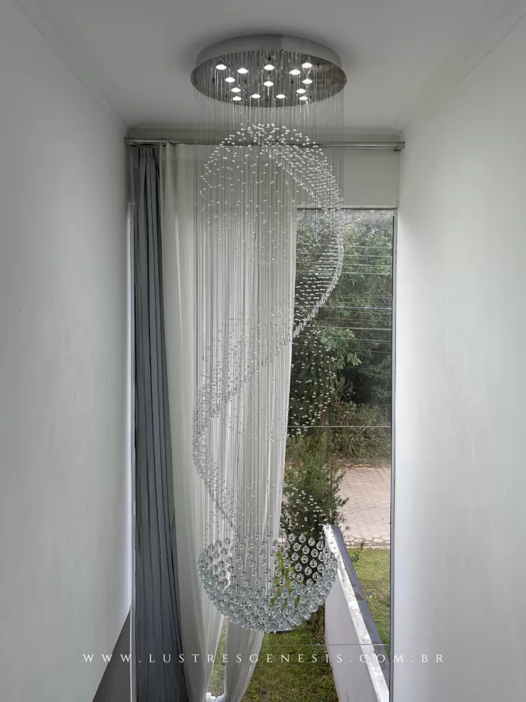 Lustre espiral de cristal para pé-direito duplo, com design cascata vertical e esferas suspensas formando movimento curvo elegante, ideal para iluminação de escadas e ambientes altos.