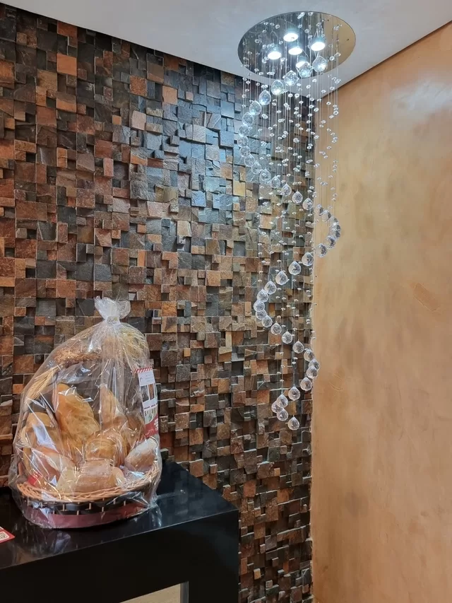 Cristais lapidados redondos alinhados sobre uma superfície cinza fosca em estúdio fotográfico, dispostos em sequência com tamanhos variados, refletindo a luz de forma uniforme e destacando brilho, simetria e precisão no corte, ideais para composição de lustres decorativos.