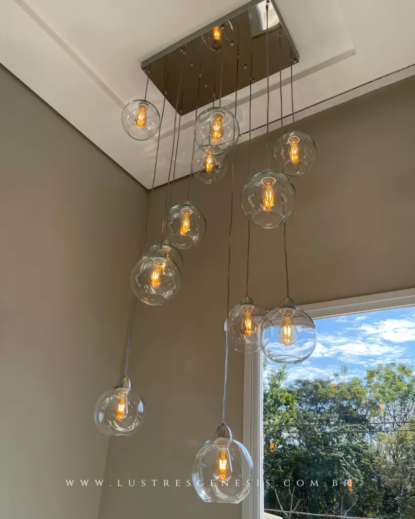 Lustre pendente cascata com globos de vidro transparente e lâmpadas estilo Edison, ideal para pé-direito duplo e escadas, com design moderno e iluminação decorativa sofisticada.