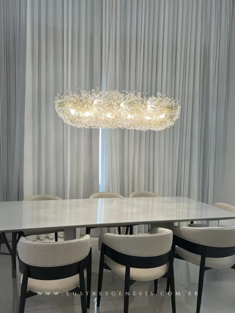 Lustre moderno dourado para sala de jantar, com design linear e estrutura orgânica iluminada por múltiplos pontos de luz, ideal para mesa retangular.