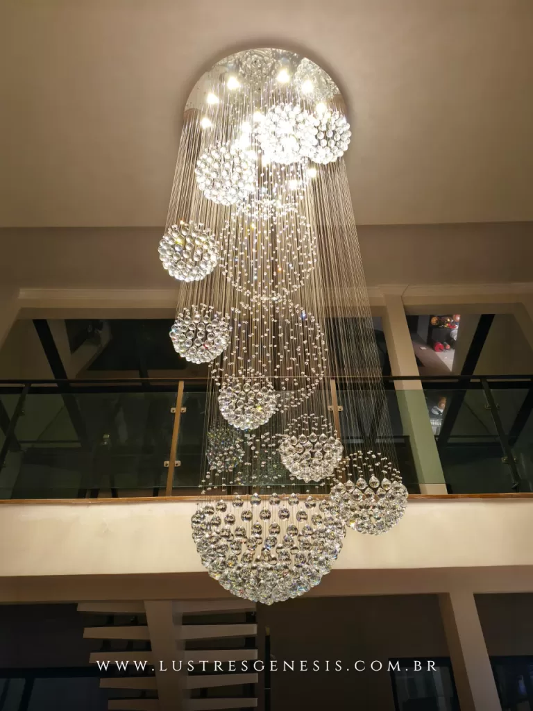 Lustre de cristal para pé-direito duplo com esferas suspensas em cascata, iluminação sofisticada e efeito brilhante em hall interno de alto padrão, ideal para escadas e ambientes amplos com decoração moderna e elegante.