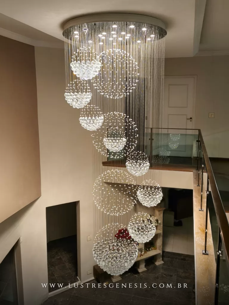 Lustre de cristal para pé-direito duplo com esferas suspensas em cascata, iluminação sofisticada e efeito brilhante em hall interno de alto padrão, ideal para escadas e ambientes amplos com decoração moderna e elegante.