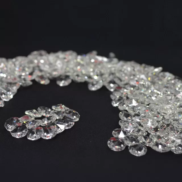 Cristais castanha K9 de 14mm transparentes dispostos sobre uma superfície escura, ideais para lustres, artesanato e feng-shui.