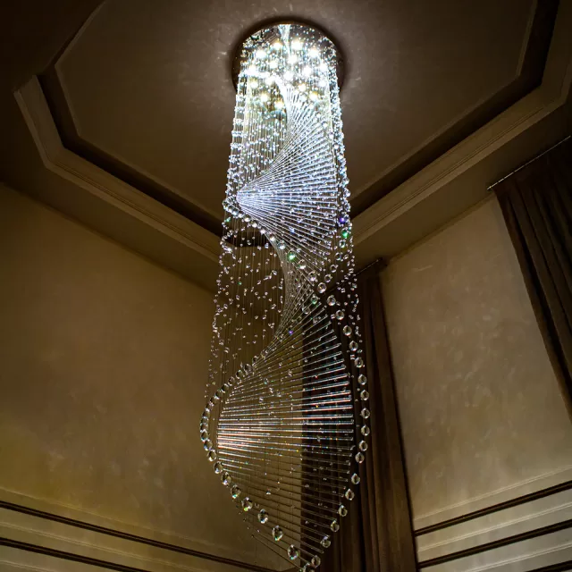Lustre de Cristal Genoma em ambiente com pé direito alto, apresentando design espiral elegante. 