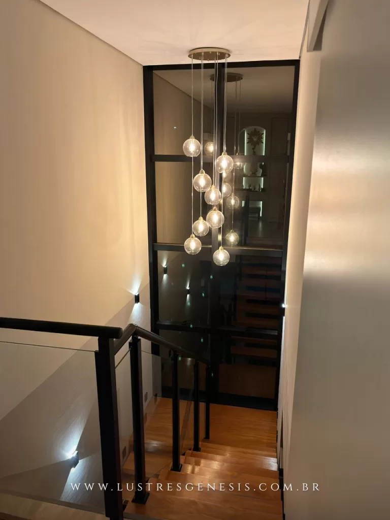 Pendente com múltiplos globos de vidro suspensos em diferentes alturas, ideal para escadas e ambientes com pé-direito duplo.