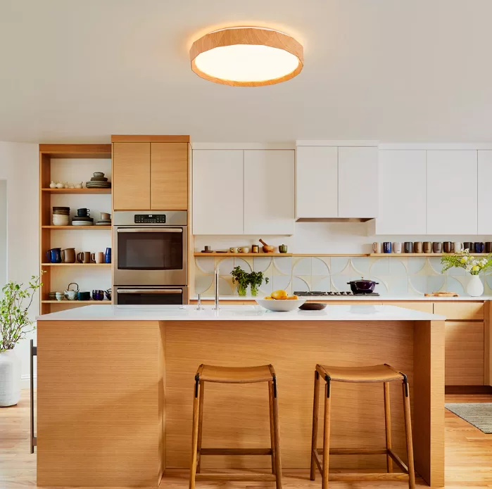 Plafon de LED multitemperatura Renki Ø48cm com acabamento em madeira instalado no teto de uma cozinha moderna, destacando iluminação elegante e ambiente aconchegante.