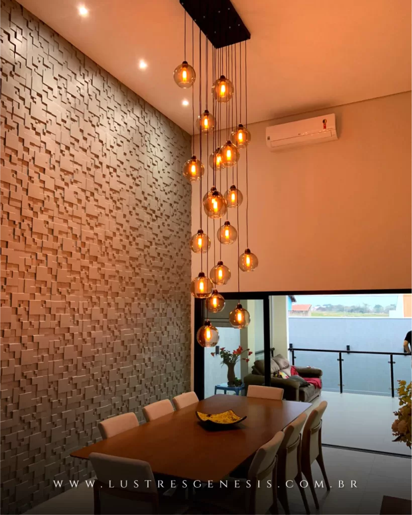 Lustre pendente Sarvah com 21 bolas de vidro fumê espelhado, instalado em pé direito duplo, iluminando ambiente sofisticado.