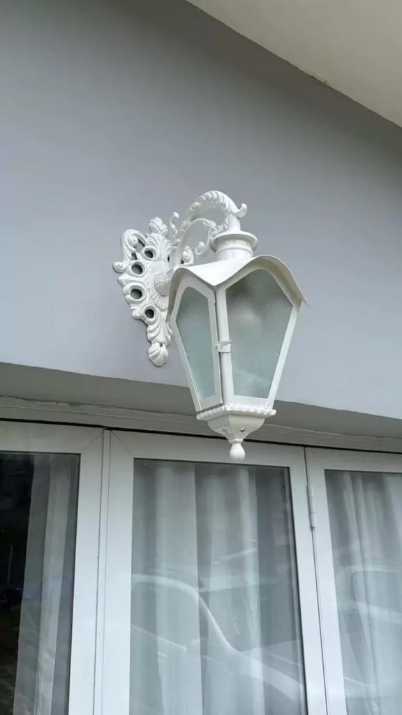 Luminária arandela colonial branca instalada em parede externa Lustres Gênesis loja online de Lustres e Iluminação Decorativa