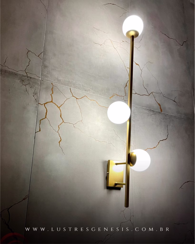 Arandela moderna tripla com globos leitosos instalada em parede com acabamento marmorizado. Lustres Gênesis loja online de Lustres e Iluminação Decorativa