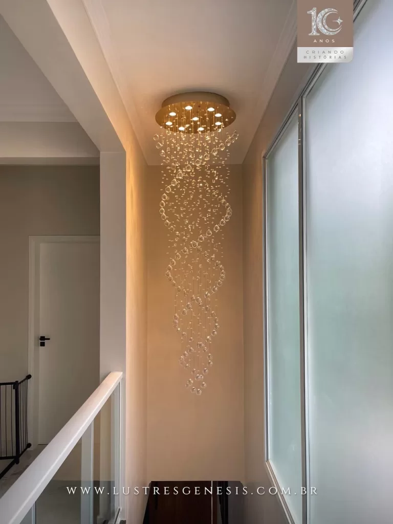 Lustre pendente em espiral com cristais suspensos e base redonda embutida, ideal para escadas e ambientes com pé-direito alto.