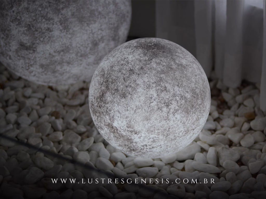 Luminária de chão em formato de esfera lua Moon Ø23cm iluminando ambiente interno com pedras decorativas.