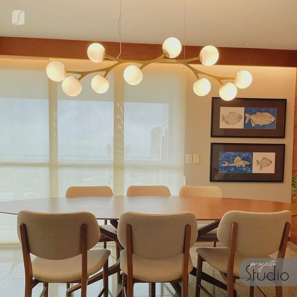 Lustre pendente moderno Colli dourado instalado sobre mesa de jantar em ambiente gourmet, com design contemporâneo e luz suave.