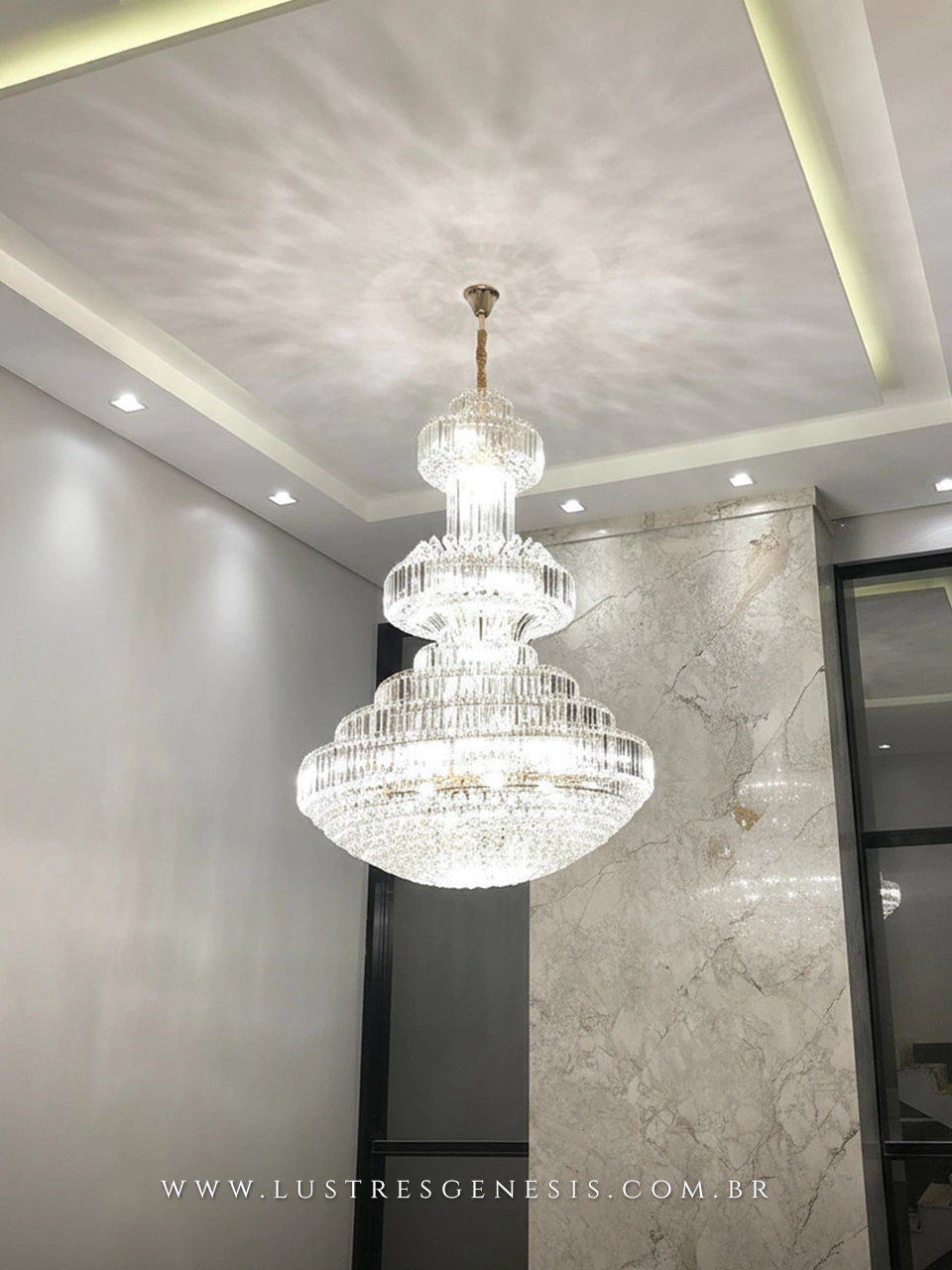 Lustre de cristal Las Vegas com cristais transparentes, modelo grande de Ø120x180 cm, instalado em ambiente com pé direito duplo.