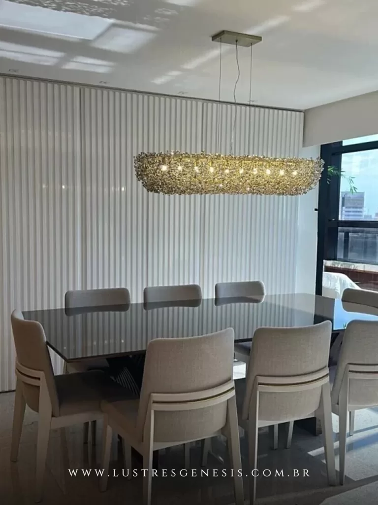 Lustre pendente retangular de cristal Ø120x40x20 instalado sobre mesa de jantar com oito cadeiras, em ambiente moderno e iluminado.