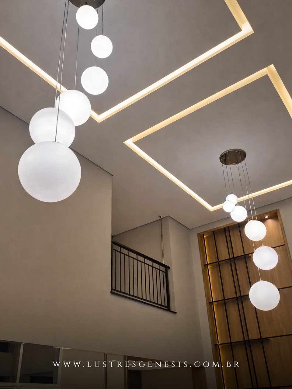 Lustre pendente de 6 globos leitosos da Lustres Gênesis instalado no condomínio Galleria Boulevard, com design moderno em esferas de vidro branco suspensas em diferentes alturas, ideal para ambientes com pé direito duplo, proporcionando iluminação elegante e sofisticada.