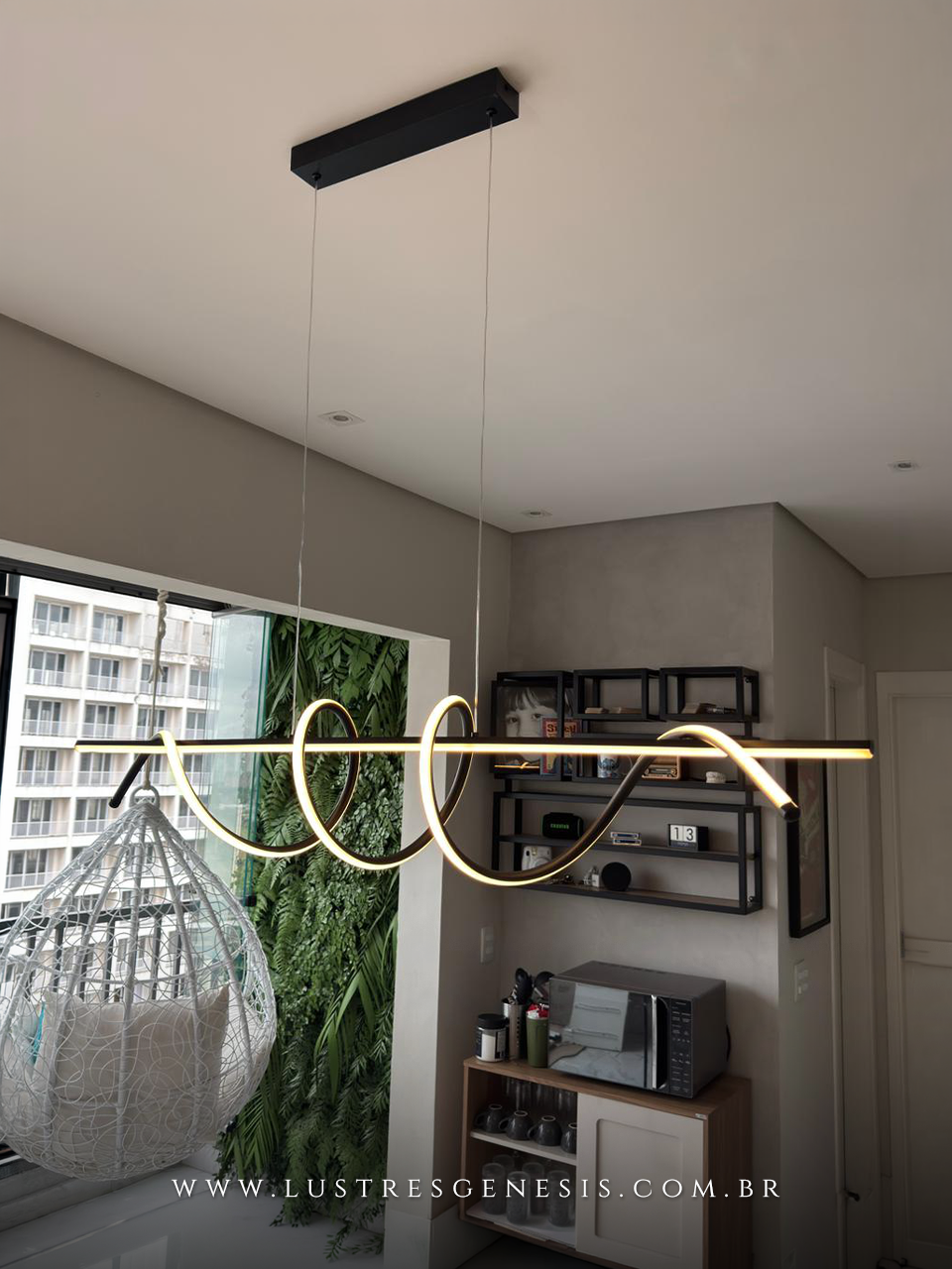 Pendente Zeon da Lustres Gênesis instalado na casa da influenciadora Zabetta Macarini, com design moderno em LED linear ondulado, suspenso por cabos finos sobre ambiente contemporâneo, proporcionando iluminação elegante e sofisticada.