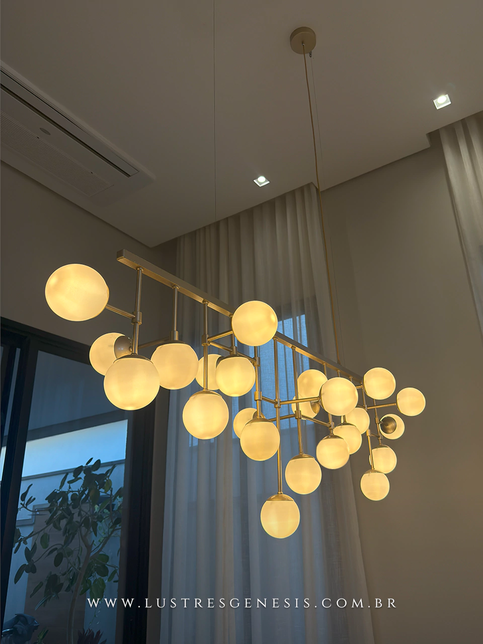 Luminária de teto pendente modelo Cacho Jabuticaba com 23 globos leitosos acesos, ideal para sala de jantar e pé direito duplo.