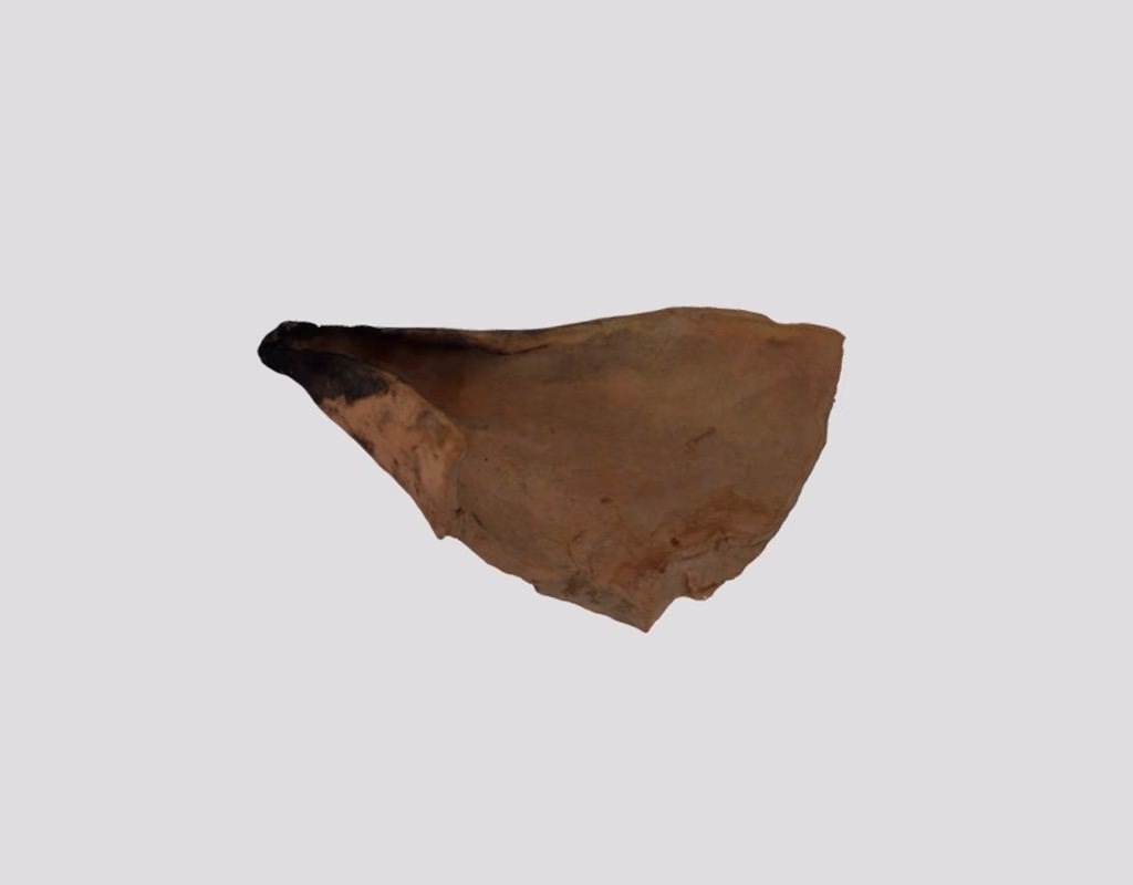 Lamparina primitiva de cerâmica moldada à mão, com formato simples em concha e extremidade escurecida pelo fogo. Utilizada para conter óleo e sustentar um pavio, representa uma das formas mais antigas de iluminação artificial desenvolvidas pela humanidade.