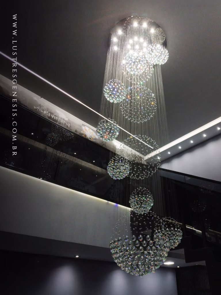 Lustre de Cristal Yôda da Lustres Gênesis instalado em uma escada de pé-direito duplo, com esferas de cristal suspensas em composição cascata para um ambiente sofisticado e contemporâneo.