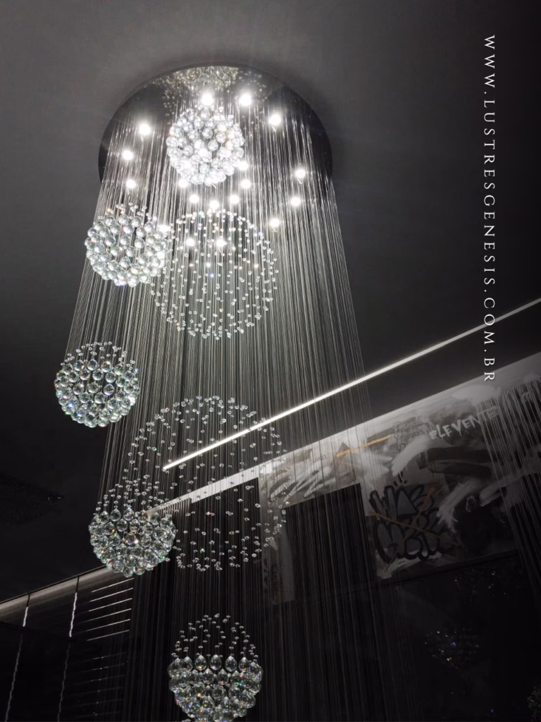 Lustre de Cristal Yôda da Lustres Gênesis instalado em uma escada de pé-direito duplo, com esferas de cristal suspensas em composição cascata para um ambiente sofisticado e contemporâneo.