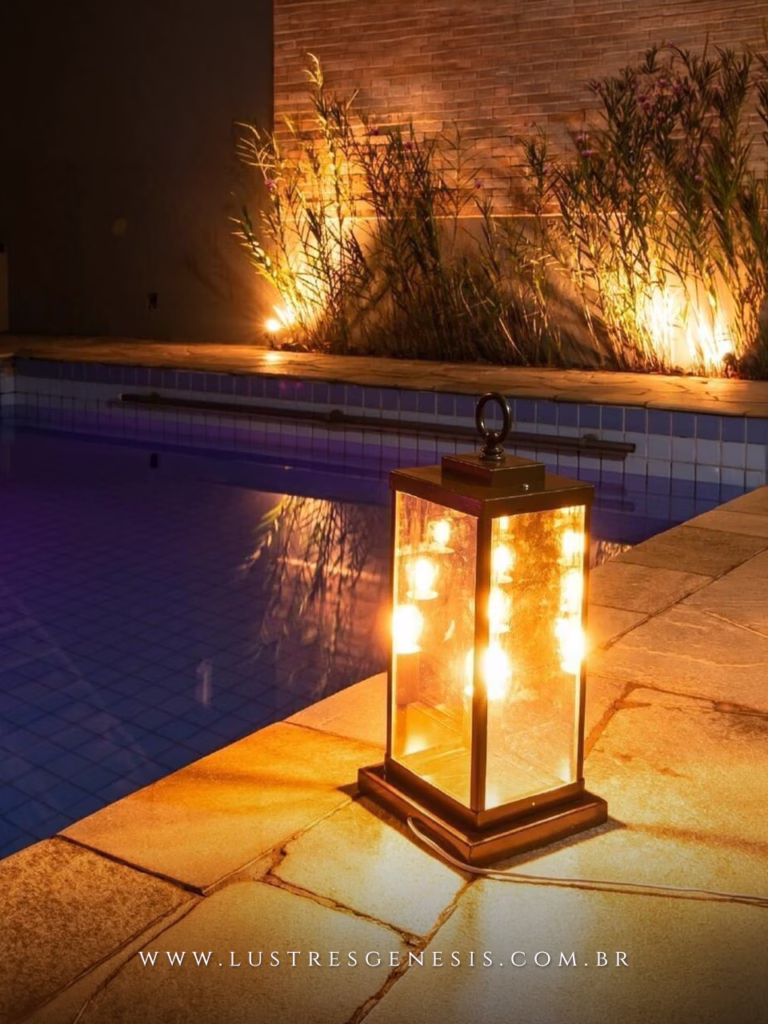 Luminária de mesa Abajur Reflex 40,5cm estilo lanterna, com estrutura preta e vidro, iluminando área externa ao lado de cadeira decorativa.