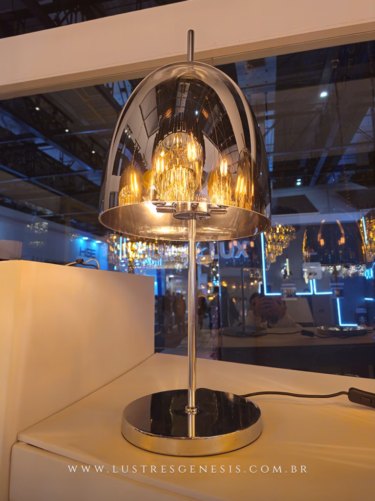 Abajur moderno de vidro cromado Dome aceso, ideal para leitura, quartos, escritório e escrivaninhas, exibido sobre uma mesa em ambiente sofisticado.