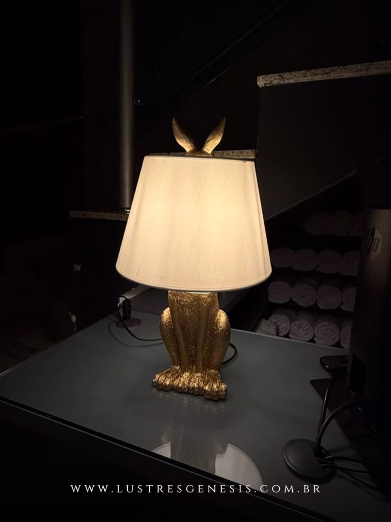 Luminária de mesa com base em formato de coelho dourado e cúpula branca, ideal para leitura, quartos, escritórios e escrivaninhas.