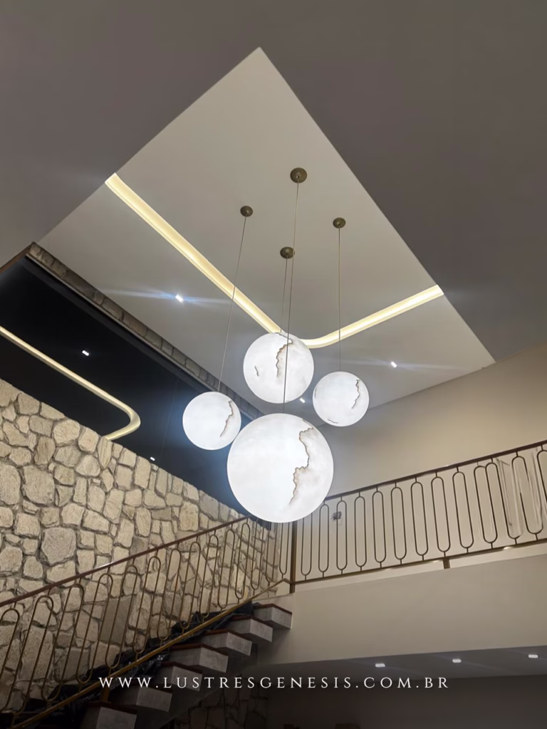 Lustre Esferas Mármore da Lustres Gênesis instalado em escada com pé-direito alto.